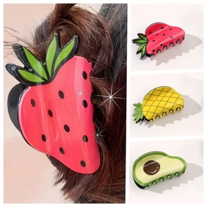 Detail shots of strawberry, pineapple, and avocado fruit hair claws for elegant updos