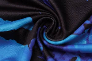 Macro di tessuto blu scuro con stampa astratta, trama a maglia fitta e morbido drappeggio