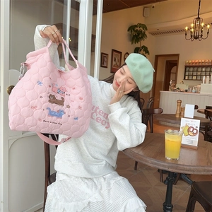 Quilted pink crossbody bag with cat embroidery and adjustable shoulder strap detail