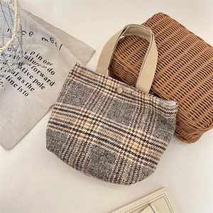 Dettaglio borsa vintage in lana scozzese con manici in tela e chiusura a scatto in metallo