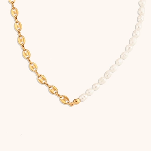 Macro view of gold coffee bean chain spliced with white pearls for a modern necklace