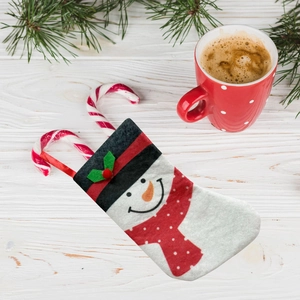 Christmas snowman felt gift bag with red polka dot scarf on white wood background