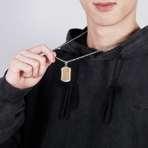 Men's retro punk dog tag necklace in gold and silver steel worn by a male model