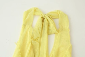 Detail of yellow mesh top showing the intricate knot design and sheer fabric texture