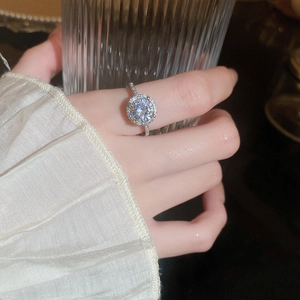 Detailed close-up of a halo-set zircon ring with micro-pave diamonds on silver band
