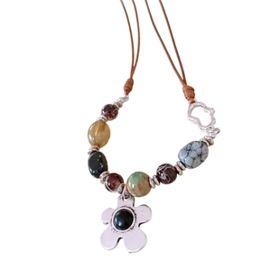 Bohemian floral pendant necklace with brown cord and colorful agate beads on white back