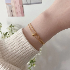 Close-up of double-layer gold sterling silver bracelet with snake and rope chain style
