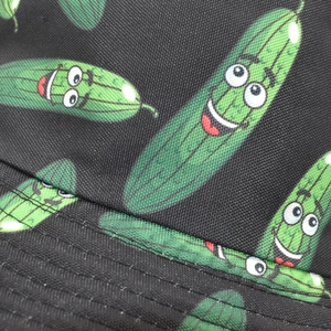 Macro shot of durable black twill fabric with vibrant green cartoon cucumber pattern