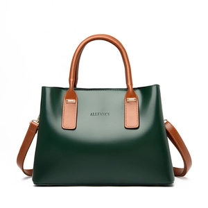 Dark green leather tote bag with brown handles and adjustable shoulder strap