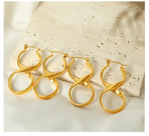 Detail view of twisted gold hoop earrings with mirror finish on stone display