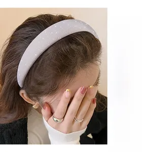 Close-up of wide sparkling sponge headband with fine rhinestones in light grey finish
