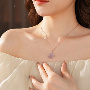 Close-up of purple chalcedony Buddha pendant necklace on model collarbone
