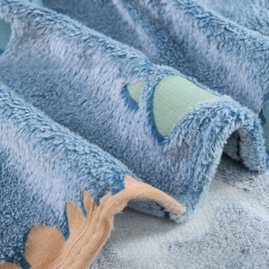 Close-up of soft flannel glow-in-the-dark blanket with green and orange patches