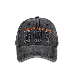 Detailed close-up of washed cotton baseball cap with BOY letter embroidery and frayed edges