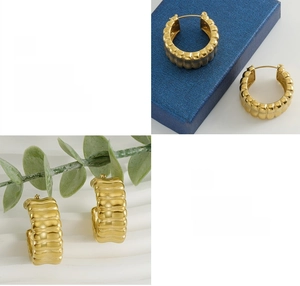 Detailed view of gold U-shaped hoop earrings with vertical wave texture and high polish finish