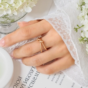 Close-up of elegant 18K gold-plated knotted ring worn by a model in a minimal setting