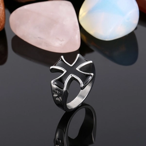 Close-up of gothic stainless steel cross ring with black enamel on stone background