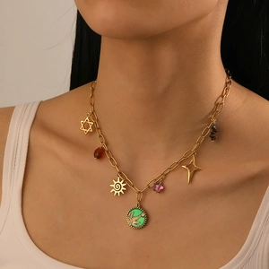 Detail of bohemian gold chain necklace featuring green sun charms and colorful beads on a model