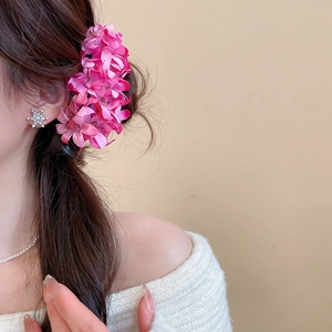 Detail of pink fabric flower hair claw and sparkling snowflake rhinestone earrings