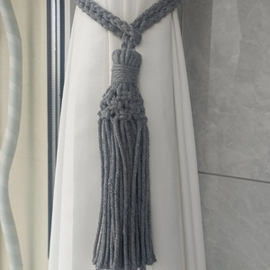 Detail view of handmade grey cotton woven curtain tieback with long decorative tassels