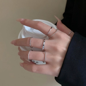 Detail of silver minimalist ring set with twisted texture and smooth band on hands