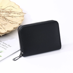 Close-up of black lychee grain leather wallet with a secure metal zipper detail