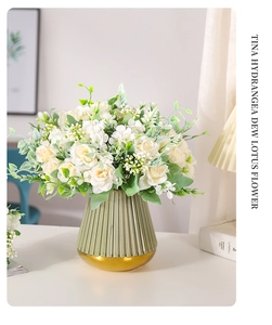 Detalle de ramo de rosas y hortensias artificiales en un jarrón de vidrio verde