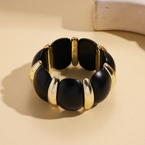 Detail of wide stretch bracelet with alternating matte black and gold metallic segments