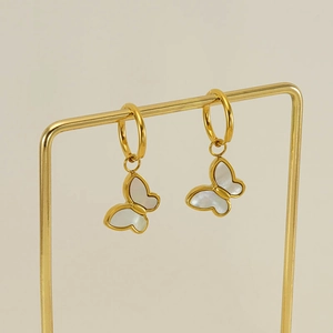 Detailed close-up of gold butterfly hoop earrings with elegant white shell inlay details