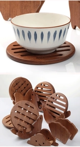 Detail of round wooden trivet set with creative animal chicken holder and striped cutouts