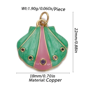 Macro detail of 14K gold plated shell pendant with green pink enamel and copper base