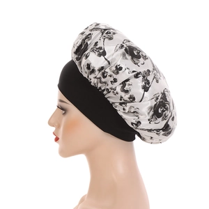 Detail einer großen Satin-Schlafmütze mit schwarz-weißem Blumendruck auf einem Model