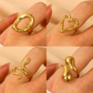 Gold stainless steel textured heart and snake ring set displayed on beige silk fabric