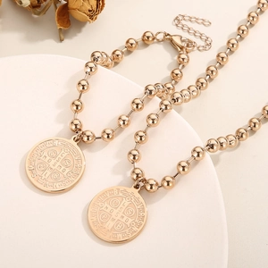 Detailed view of rose gold St. Benedict medal pendants on delicate bead chains