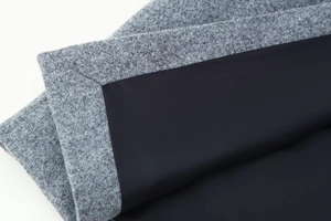 Close-up of grey wool blend fabric and black lining showing premium sewing detail
