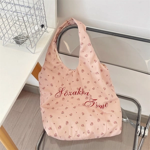 Close-up of a floral canvas tote bag with Zozakka Time text on a modern chair