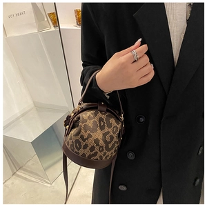 Close-up of a leopard print leopard print cylinder bag styled with a black blazer