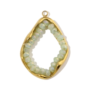 Detailed macro of a teardrop-shaped gold titanium steel pendant with green crystal beads