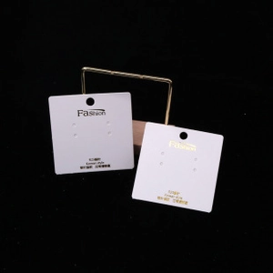 Detail of white cardboard earring display cards with gold foil and black printed text