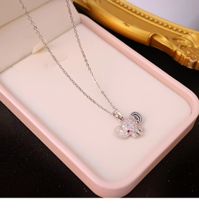 Macro shot of silver elephant pendant with inlaid zircons in a pink velvet jewelry box