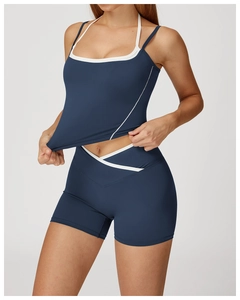 Detail des marineblauen Yoga-Sets mit High-Waist-Shorts, weißen Paspeln und Cross-Waist-Design
