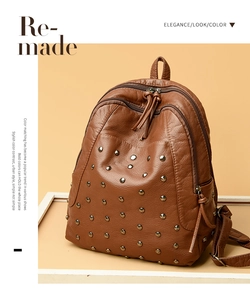 Detail of brown leather backpack with silver rivets on a beige fashion layout