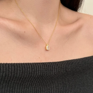 Golden S925 sterling silver necklace with rectangular zircon worn by a model on the collarbone