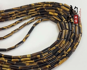 Macro detail of natural yellow tiger eye cylindrical beads with smooth polished texture