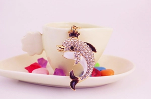 Macro detail of dolphin keychain with sparkling rhinestones and black enamel finish