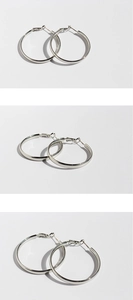 Detailed views of polished silver oversized hoop earrings from multiple angles on white
