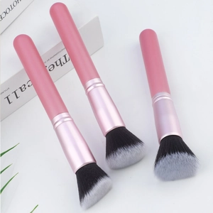 Detail of pink makeup brush set with black and white gradient bristles on white background
