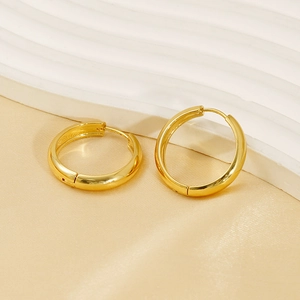 Minimalist 18K gold plated stainless steel hoop earrings on elegant silk background