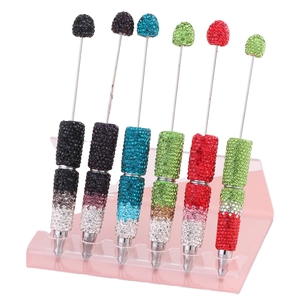Penne fai-da-te creative con perline margherite e strass colorati su supporto espositivo