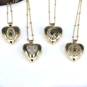 Detail view of four gold-plated heart lockets with Virgin Mary and moon patterns